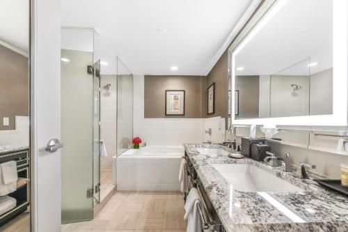 ein Badezimmer mit zwei Waschbecken und einem großen Spiegel in der Unterkunft The Madison Hotel in Washington