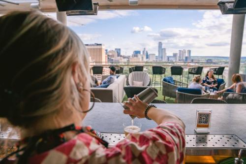 a woman sitting at a table looking at her cell phone at AC Hotel by Marriott Austin-University in Austin