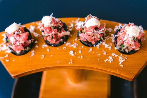 a group of four sushi on a wooden plate at AC Hotel by Marriott Austin-University in Austin