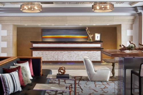 a living room with a piano and a table at Rochester Airport Marriott in Rochester