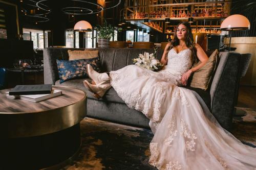 a woman in a wedding dress sitting on a couch at AC Hotel by Marriott Austin-University in Austin