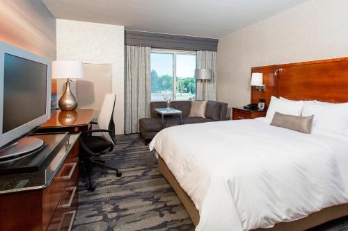 a hotel room with a bed and a flat screen tv at Rochester Airport Marriott in Rochester