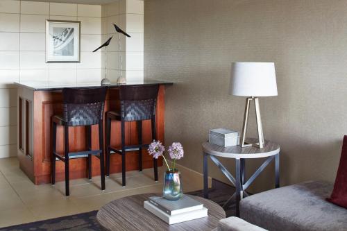a living room with a table with chairs and a bar at Rochester Airport Marriott in Rochester