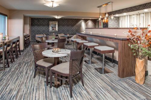 a restaurant with tables and chairs and a bar at Rochester Airport Marriott in Rochester