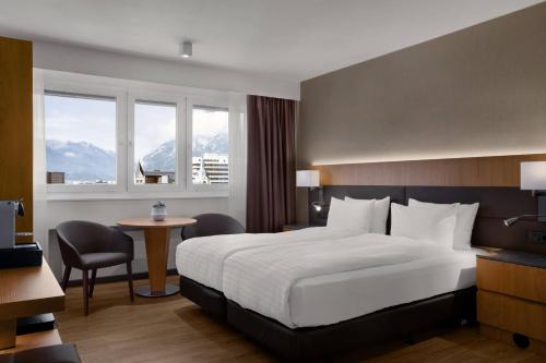 a hotel room with a bed and a desk and a table at AC Hotel by Marriott Innsbruck in Innsbruck