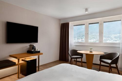a hotel room with a bed and a table and a tv at AC Hotel by Marriott Innsbruck in Innsbruck