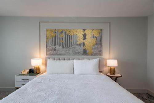 a bedroom with a white bed and two lamps at Castle Hotel, Autograph Collection in Orlando