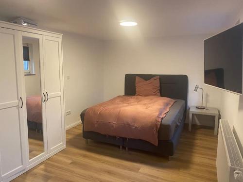 1 dormitorio con cama y espejo en Klein aber oho! Neues Apartment in Stadt- und Fuldanähe en Kassel