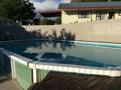 a swimming pool in front of a house at Alexandra Garden Court Motel in Alexandra