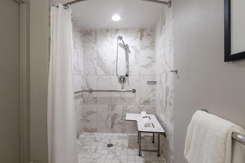 a white bathroom with a shower and a sink at Castle Hotel, Autograph Collection in Orlando