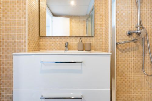 uma casa de banho com um lavatório branco e um chuveiro em Piso Estrella 031 em Torre del Mar