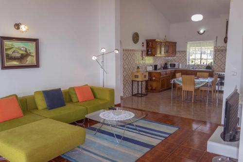 a living room with a green couch and a table at Porto Martins Bay Apartments AL in Porto Martins