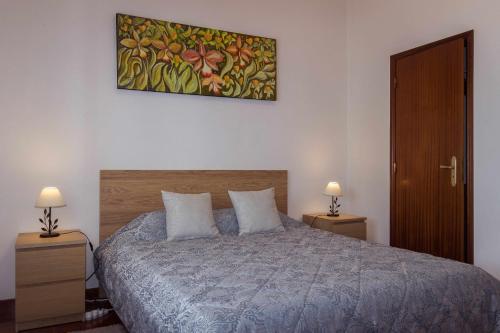 Porto Martins的住宿－Porto Martins Bay Apartments AL，一间卧室配有一张带2个床头柜和2盏灯的床。