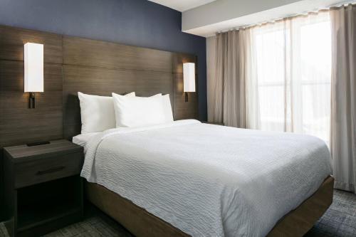 a bedroom with a large bed and a large window at Residence Inn by Marriott Tulsa South in Tulsa