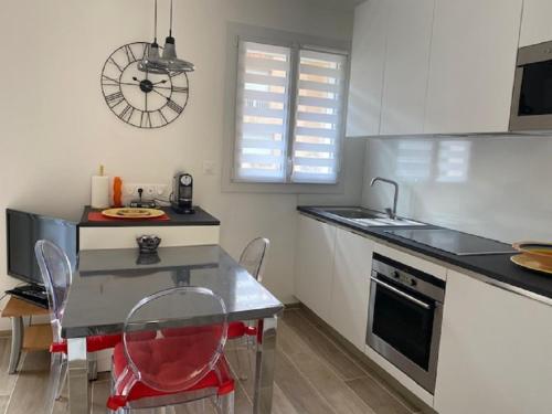 une cuisine avec un comptoir, une table et des chaises dans l'établissement Marycel t2 avec terrasse wifi clim et garage, à Bandol