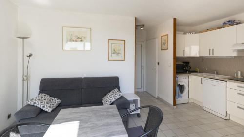 un salon avec un canapé et une table et une cuisine dans l'établissement Aquaplage- 126- Appart vue jardin- 4 pers, au Cap d'Agde