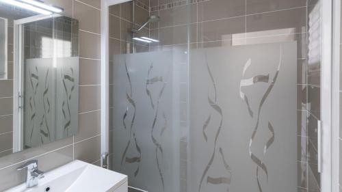 une salle de bain avec douche et lavabo dans l'établissement Aquaplage- 126- Appart vue jardin- 4 pers, au Cap d'Agde