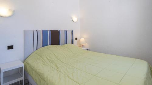 une petite chambre avec un lit et deux tables de nuit dans l'établissement Aquaplage- 126- Appart vue jardin- 4 pers, au Cap d'Agde
