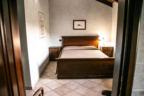 ein Schlafzimmer mit einem Holzbett in einem Zimmer in der Unterkunft Cadgal - Tenuta Valdivilla in Santo Stefano Belbo