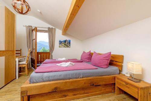 a bedroom with a large wooden bed with pink pillows at Ferienhaus Thimlefi in Reit im Winkl