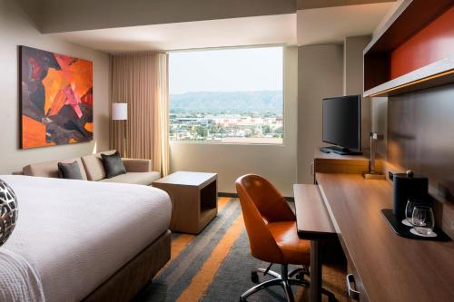 鳳凰城的住宿－鳳凰城市中心萬怡酒店，配有一张床和一张书桌的酒店客房