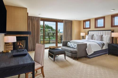 um quarto com uma cama, uma secretária e uma lareira em St. Regis Deer Valley em Park City