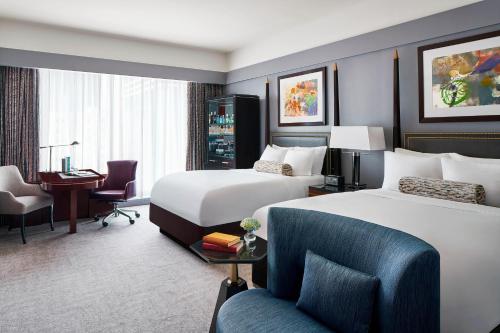 a hotel room with two beds and a desk at The Ritz-Carlton, Charlotte in Charlotte