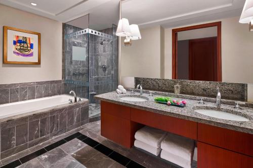 een badkamer met 2 wastafels, een bad en een douche bij The Ritz-Carlton, Charlotte in Charlotte