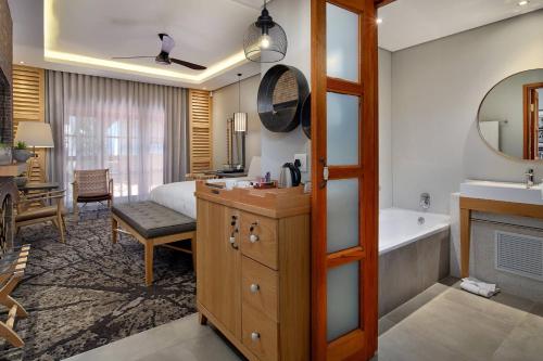 um quarto de hotel com casa de banho com banheira e um quarto em Irene Country Lodge, Autograph Collection em Centurion