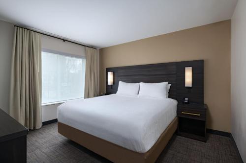 um quarto com uma cama grande e uma janela em Residence Inn New Brunswick Tower Center Blvd. em East Brunswick