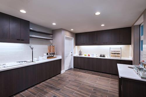 a large kitchen with brown cabinets and a counter at Residence Inn New Brunswick Tower Center Blvd. in East Brunswick