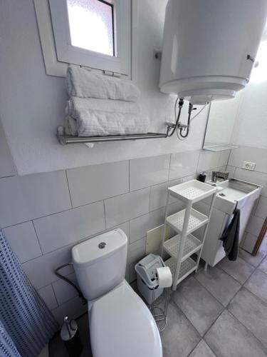 uma casa de banho com um WC, um lavatório e uma janela em Drago y Laurel em Taibique