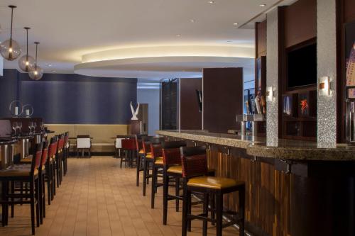 a bar in a restaurant with a row of stools at Dallas Marriott Downtown in Dallas
