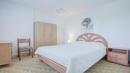 een slaapkamer met een groot bed en een stoel bij Le Cosmos - 15C - Appart spacieux- 4 pers in Cap d'Agde