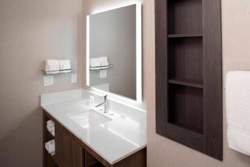 a bathroom with a white sink and a mirror at Residence Inn by Marriott Tulsa Downtown in Tulsa