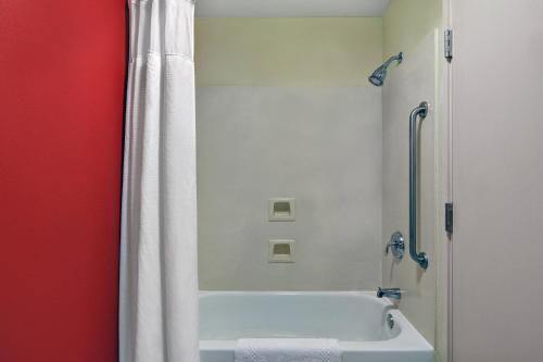 a bathroom with a bath tub with a shower curtain at Courtyard Shreveport Airport in Shreveport