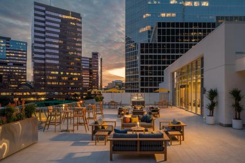 a rooftop patio with tables and chairs and buildings at The Westin Houston Medical Center - Museum District in Houston