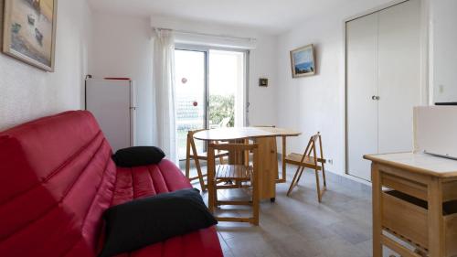 un salon avec un canapé rouge et une table dans l'établissement Santa Monica 2- 132- Appart jardin- 6 pers, au Cap d'Agde