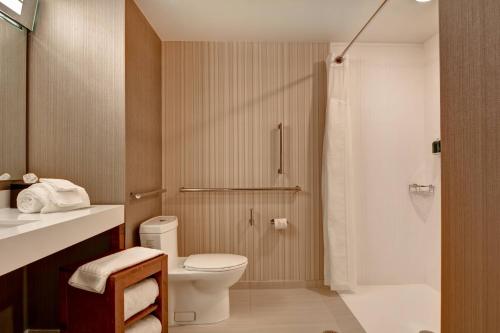 a bathroom with a toilet and a shower at Courtyard by Marriott Bentonville Rogers Promenade in Rogers