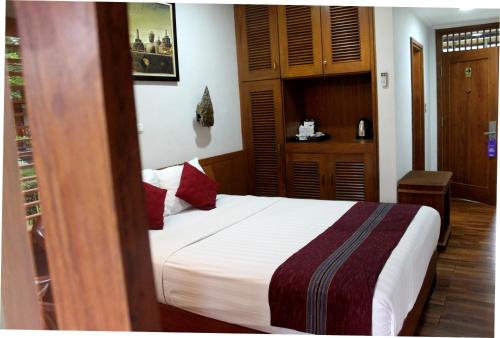 a bedroom with a bed with red pillows at Manohara Resort in Borobudur