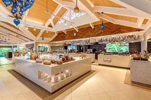 a restaurant with a buffet in the middle of a room at Sheraton Maldives Full Moon Resort & Spa in North Male Atoll