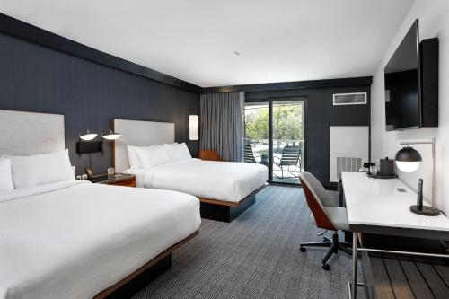 a hotel room with two beds and a desk at Courtyard by Marriott Richmond Scott's Addition in Richmond