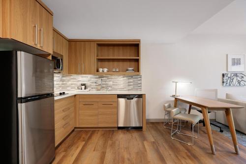 a kitchen with wooden cabinets and a wooden table at Element New York Wood Ridge in Wood-Ridge