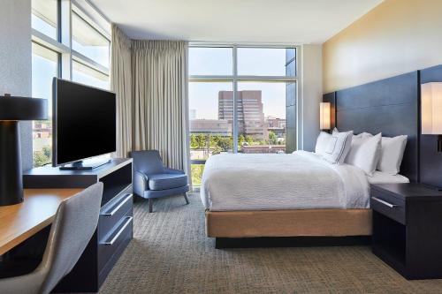Habitación de hotel con cama y escritorio con TV. en Residence Inn by Marriott Cleveland University Circle/Medical Center, en Cleveland