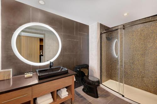 a bathroom with a shower and a sink and a mirror at Element New York Wood Ridge in Wood-Ridge