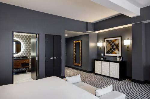a bedroom with a white bed and a bathroom at Hotel Metro, Autograph Collection in Milwaukee
