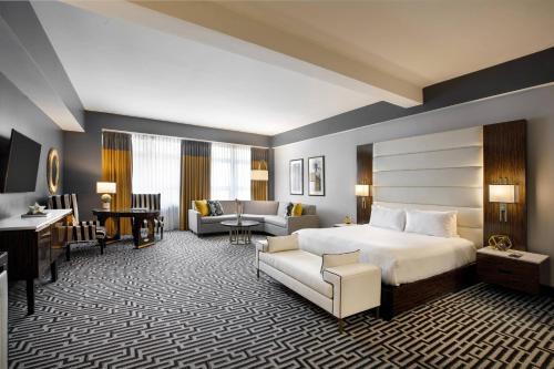 a hotel room with a bed and a living room at Hotel Metro, Autograph Collection in Milwaukee