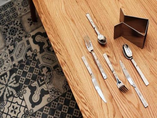 a wooden table with silverware on a wooden table at The Place Tainan in Tainan