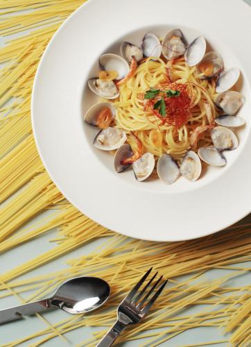 a plate of pasta and clams on a table at The Place Tainan in Tainan