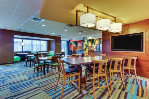 a dining room with tables and chairs and a flat screen tv at Fairfield Inn & Suites by Marriott Dunn I-95 in Dunn